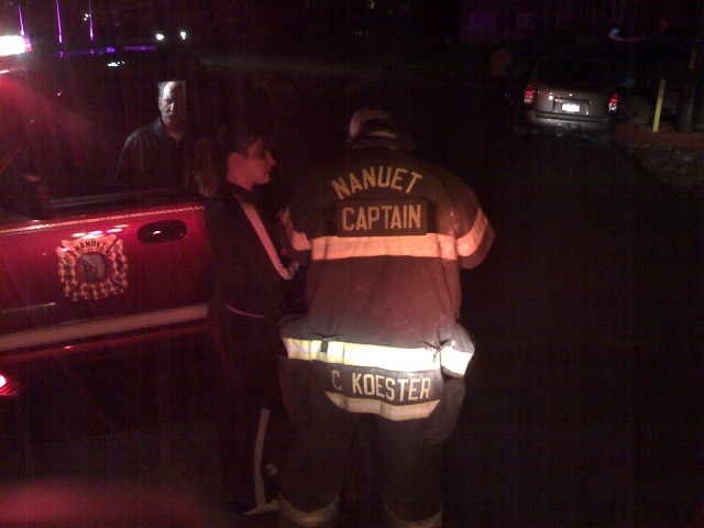 Captain Chris Koester consults with a local homeowner about a reported odor of natural gas in the area.